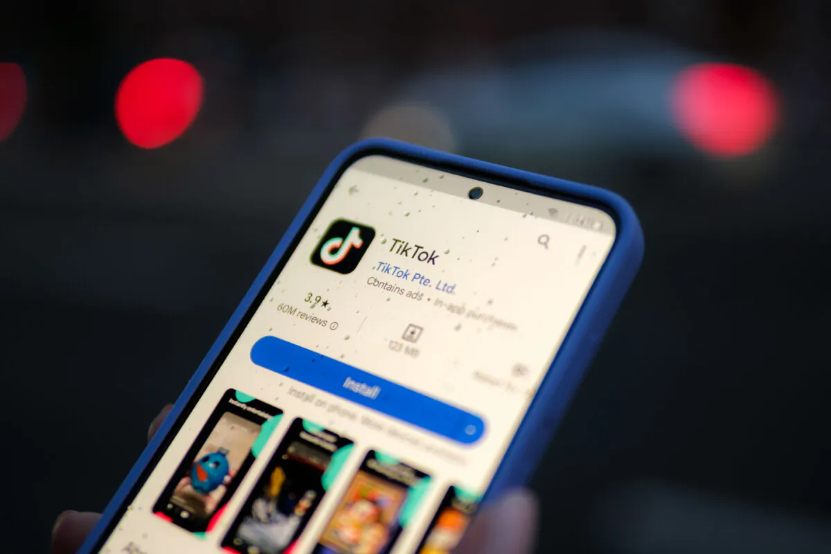 A woman holds a phone displaying the TikTok app, in this file photo, on Aug. 11, 2024. (Oleksii Pydsosonnii/The Epoch Times)
