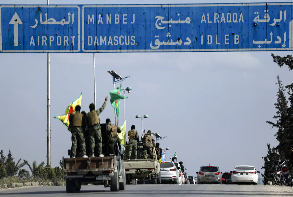 U.S.-backed Kurdish fighters stand on their vehicles, as they withdraw from two neighbourhoods in Syria's northern city of Aleppo as part of a deal with the Syrian central government, in Aleppo, Syria, on April 4, 2025. (Ghaith Alsayed/AP Photo)