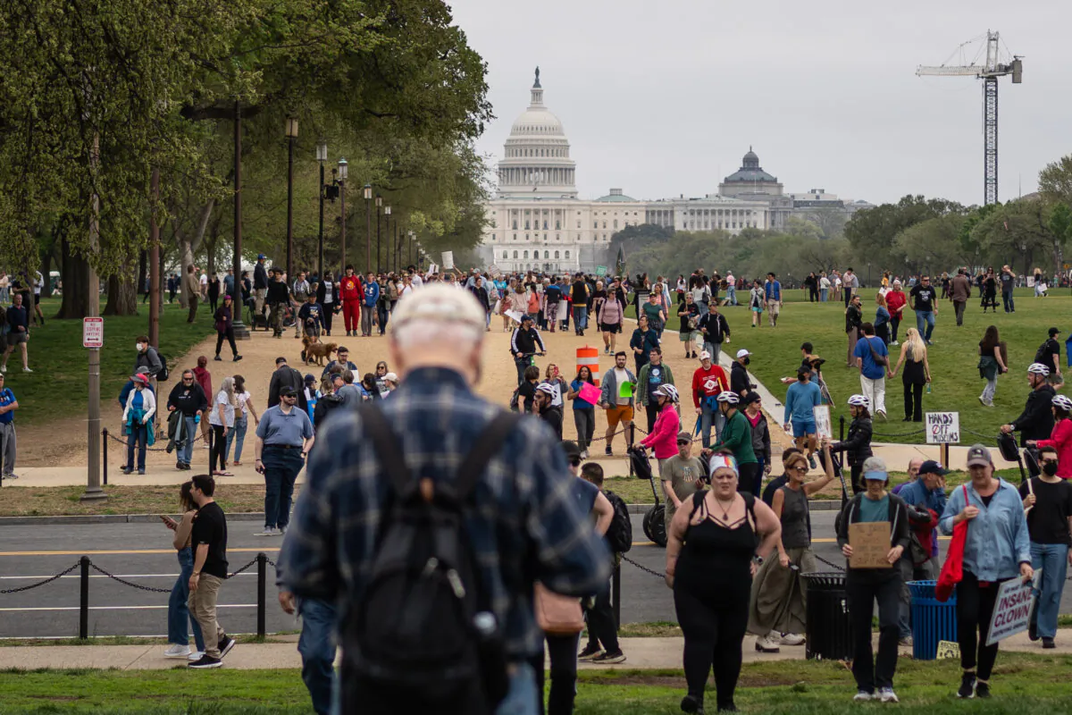 People take part in a protest against President Donald Trump and his adviser overseeing DOGE, Elon Musk, in Washington on April 5, 2025. (Madalina Vasiliu/The Epoch Times)