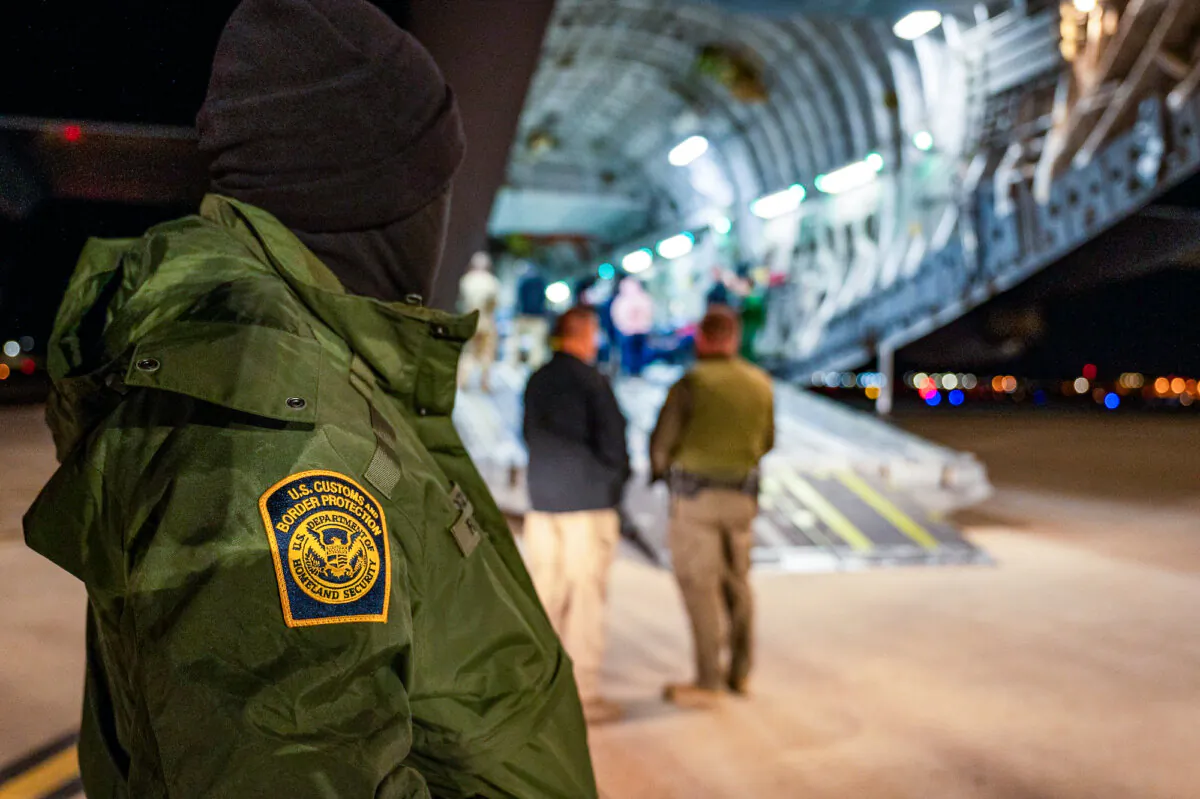A U.S. Customs and Border Protection agent watches as illegal immigrants are loaded onto an aircraft at Tucson International Airport in Tucson, Ariz., on Jan. 23, 2025. (Senior Airman Devlin Bishop/DOD)