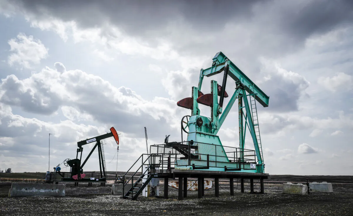 A decommissioned pumpjack (R), sits idle beside a functioning one drawing out oil and gas from a wellhead near Carstairs, Alta., on April 1, 2025. (The Canadian Press/Jeff McIntosh)
