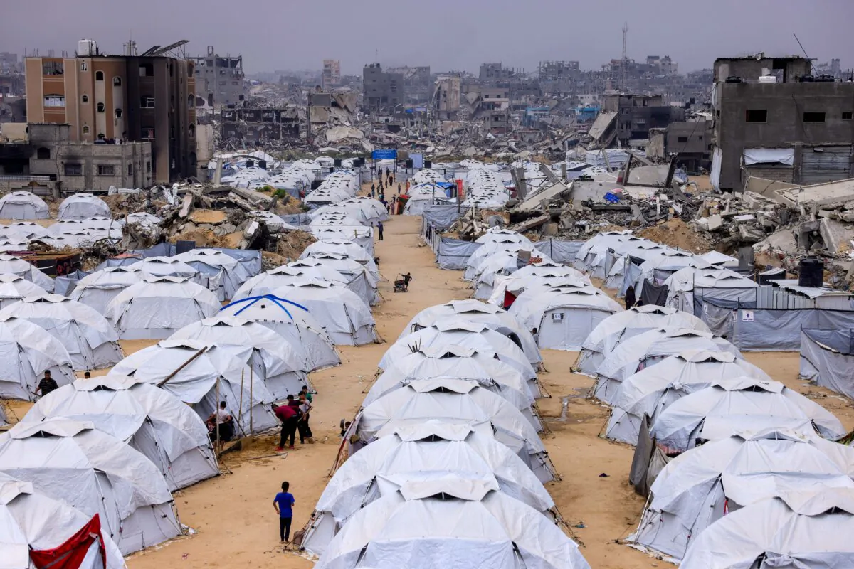 People walking amid tents set up next to the rubble of destroyed buildings at the Jabalia camp for displaced Palestinians in the northern Gaza Strip on April 8, 2025. (Bashar Taleb/AFP)