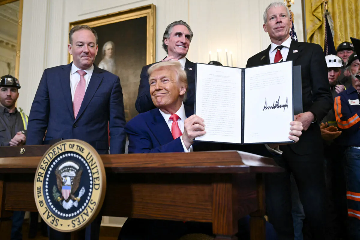 President Donald Trump displays an executive order he signed to boost coal mining and production in the United States, in the East Room of the White House on April 8, 2025. (Saul Loeb/AFP via Getty Images)