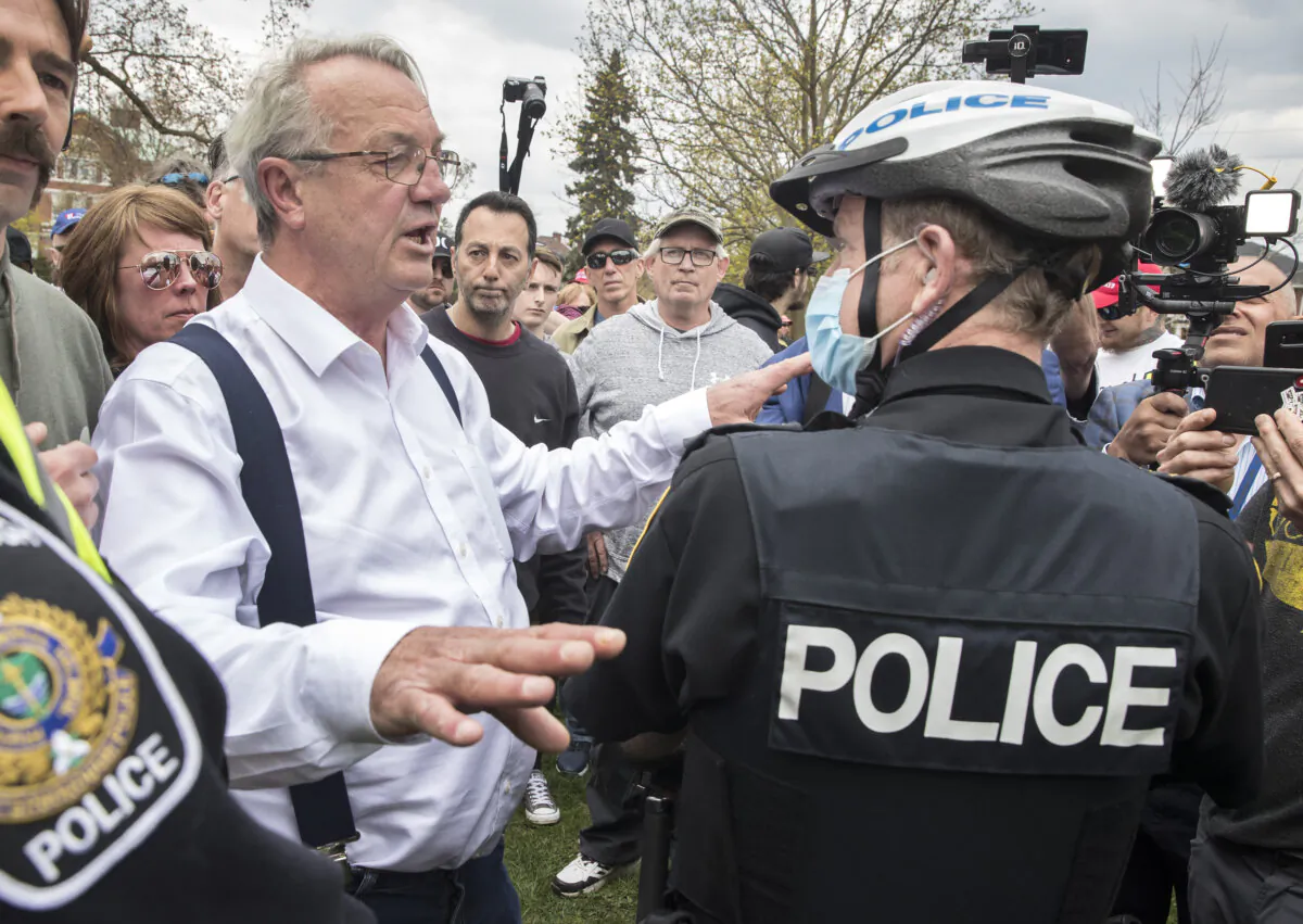 Former Ontario MPP Randy Hillier receives a ticket and a summons to appear in court for violating the province's stay-at-home-order, at a protest against government lockdown measures, on April 24, 2021. (The Canadian Press/Fred Thornhill)
