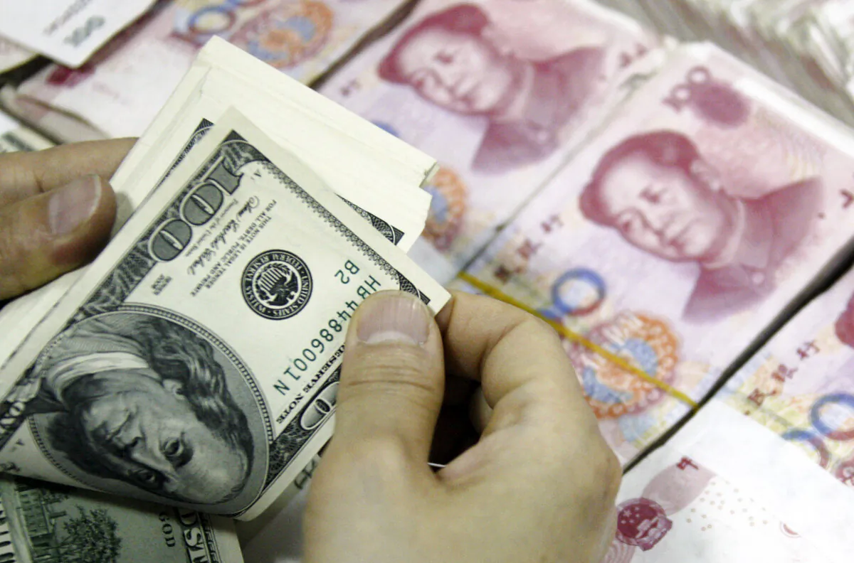 U.S. dollar notes being counted next to stacks of 100 yuan (RMB) bank notes at a bank in Huaibei, Anhui Province, China, on Sept. 24, 2013. (AFP via Getty Images)
