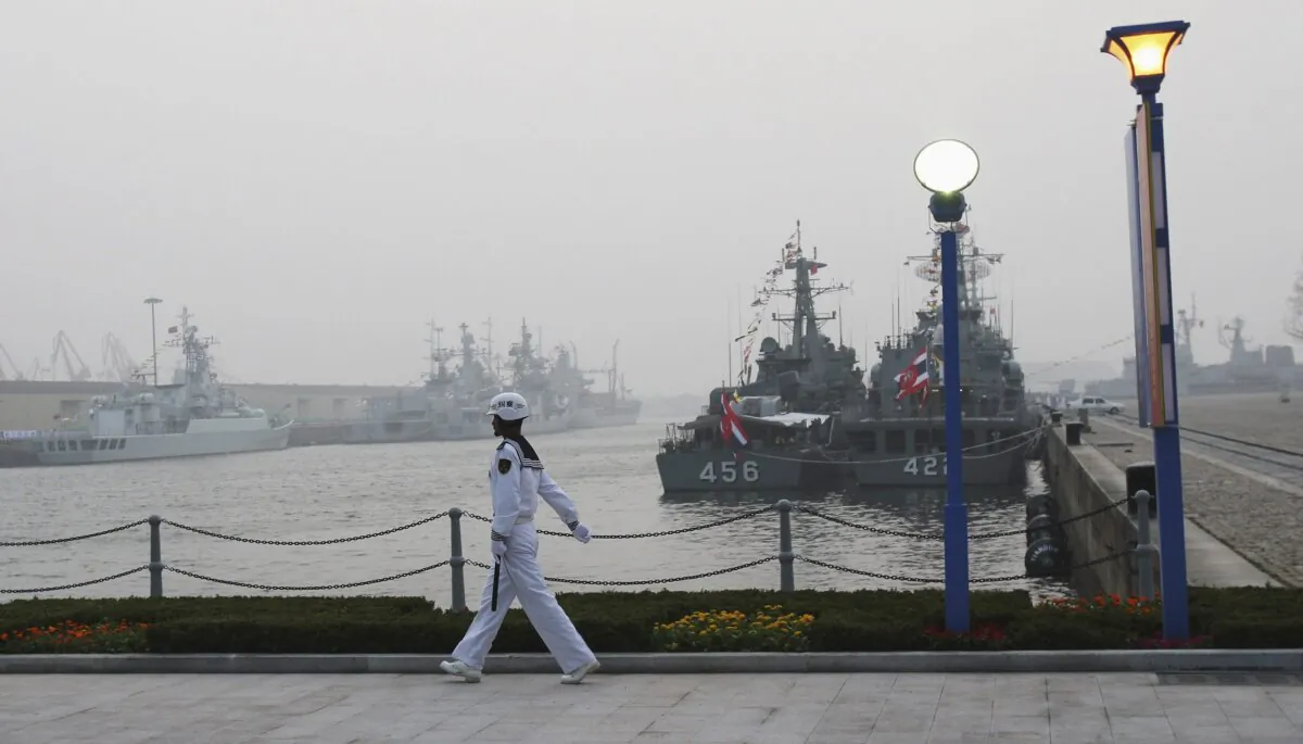A Chinese naval officer guards in front of foreign warships at Qingdao port, China's Shandong Province, in a file photo. (Guang Niu/Pool/AP Photo)