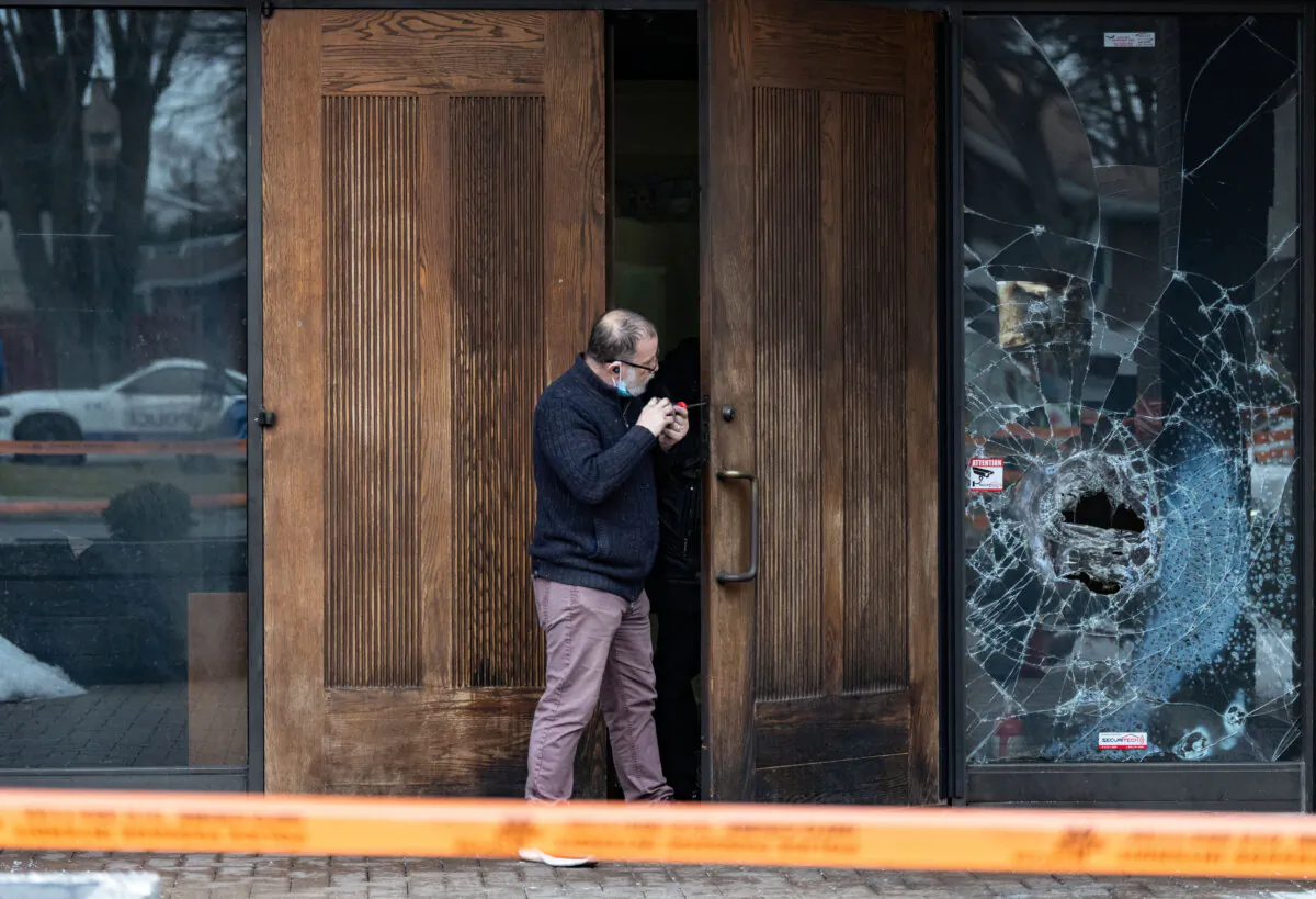 A man fixes the lock of the doors of Congregation Beth Tikvah, as police investigate an alleged arson at the synagogue in the Montreal suburb of Dollard-des-Ormeaux on Dec.18, 2024. (The Canadian Press/Christinne Muschi)