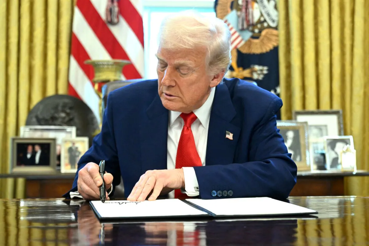 President Donald Trump signs an executive order in the Oval Office of the White House on April 9, 2025. (Saul Loeb/AFP via Getty Images)