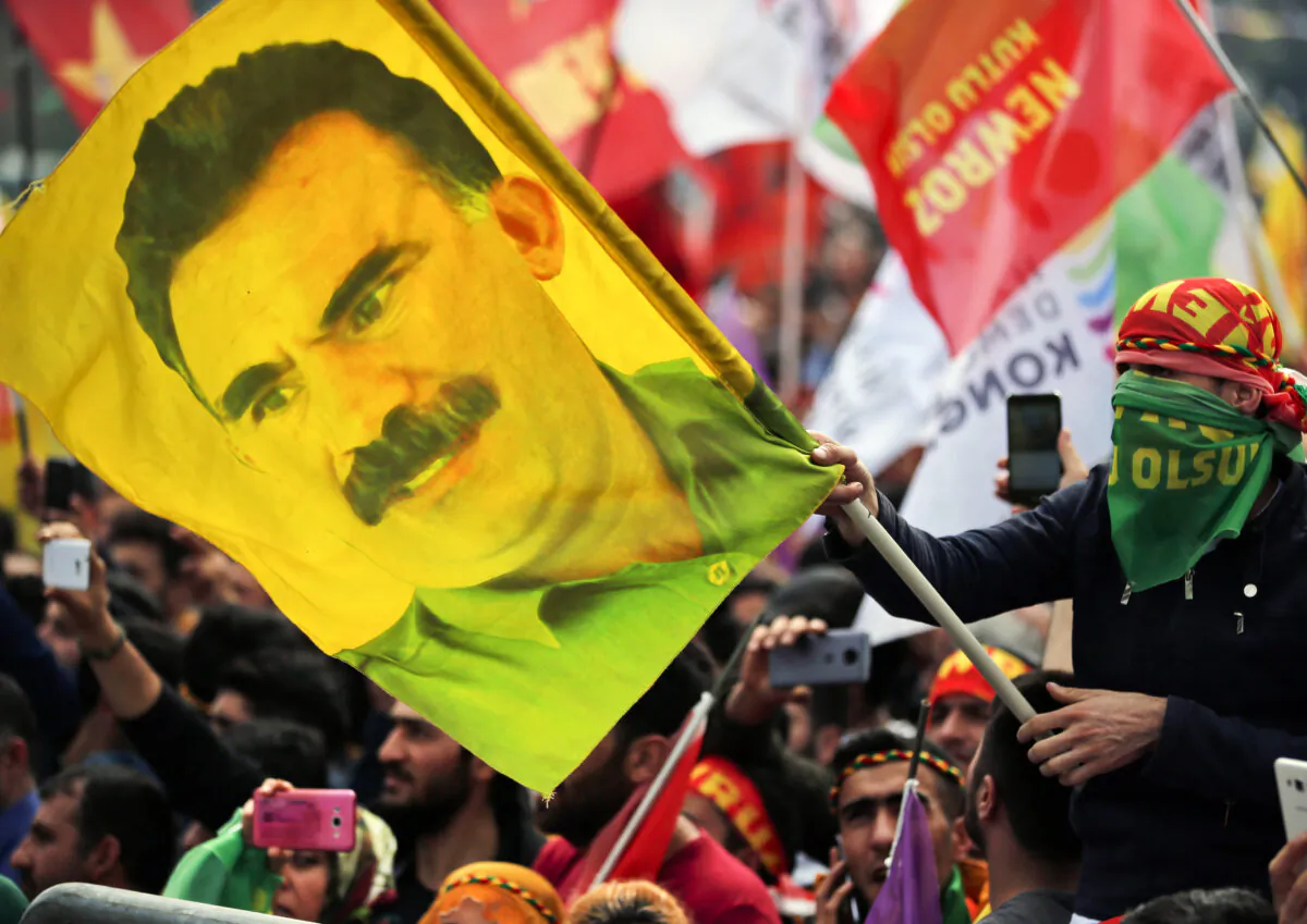 A youth holds a flag with the image of Abdullah Ocalan, the jailed leader of the rebel Kurdistan Workers' Party, in Istanbul, on March 21, 2018. (Lefteris Pitarakis/AP)