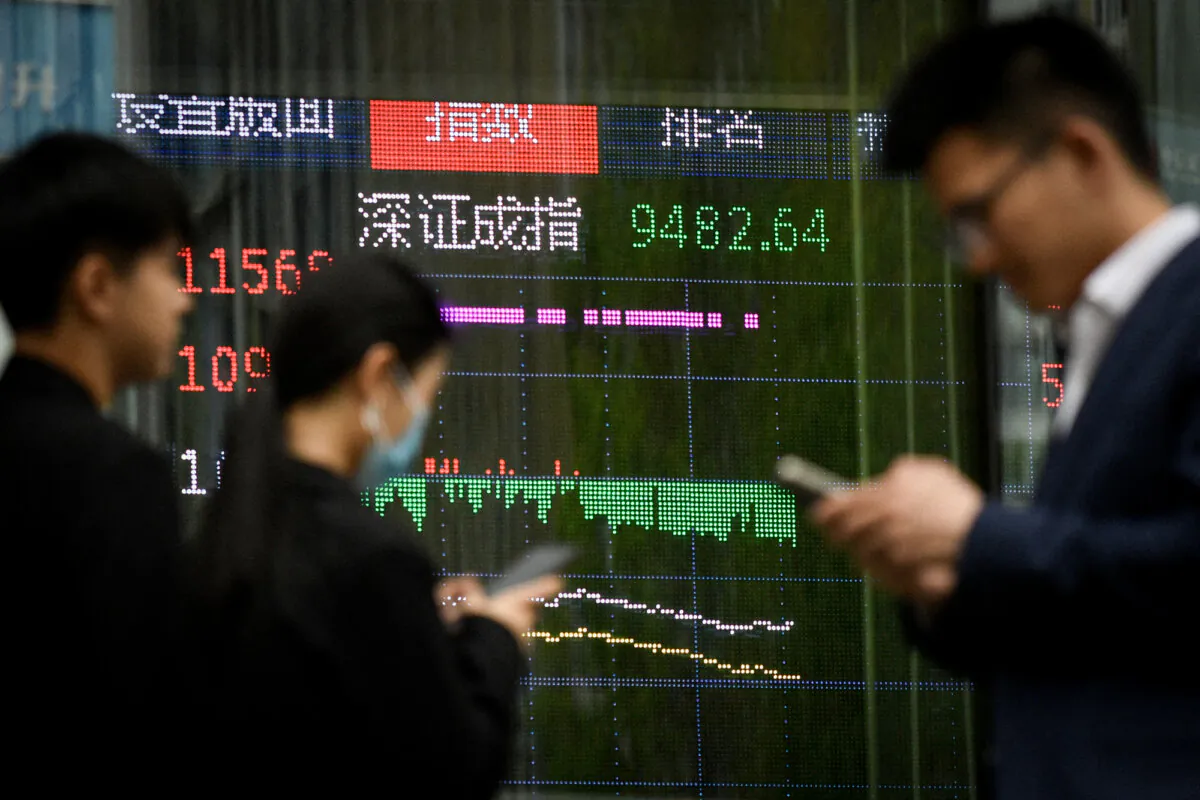 People walk past a screen showing Chinese stock market movements in Beijing on April 7, 2025. Asian markets equities collapsed on April 7 after China imposed its own hefty tariffs on the United States. (Wang Zhao/AFP via Getty Images)