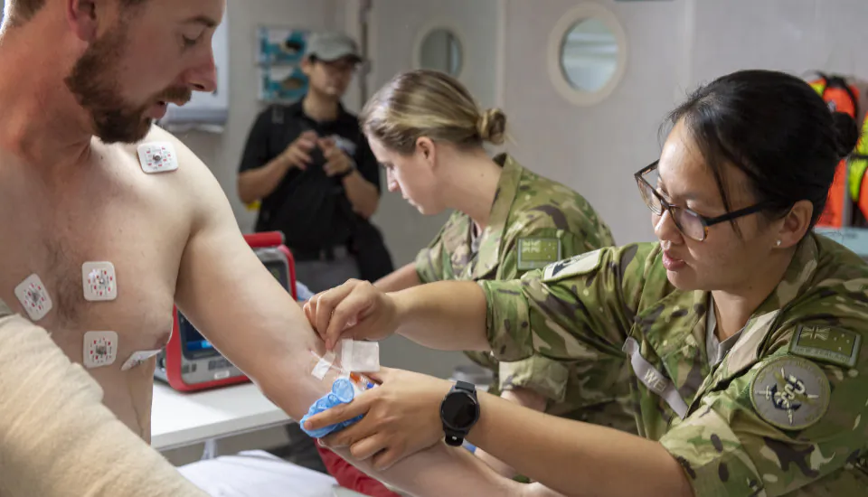 A New Zealand Defence Force medic with a patient. (Courtesy of the NZDF)