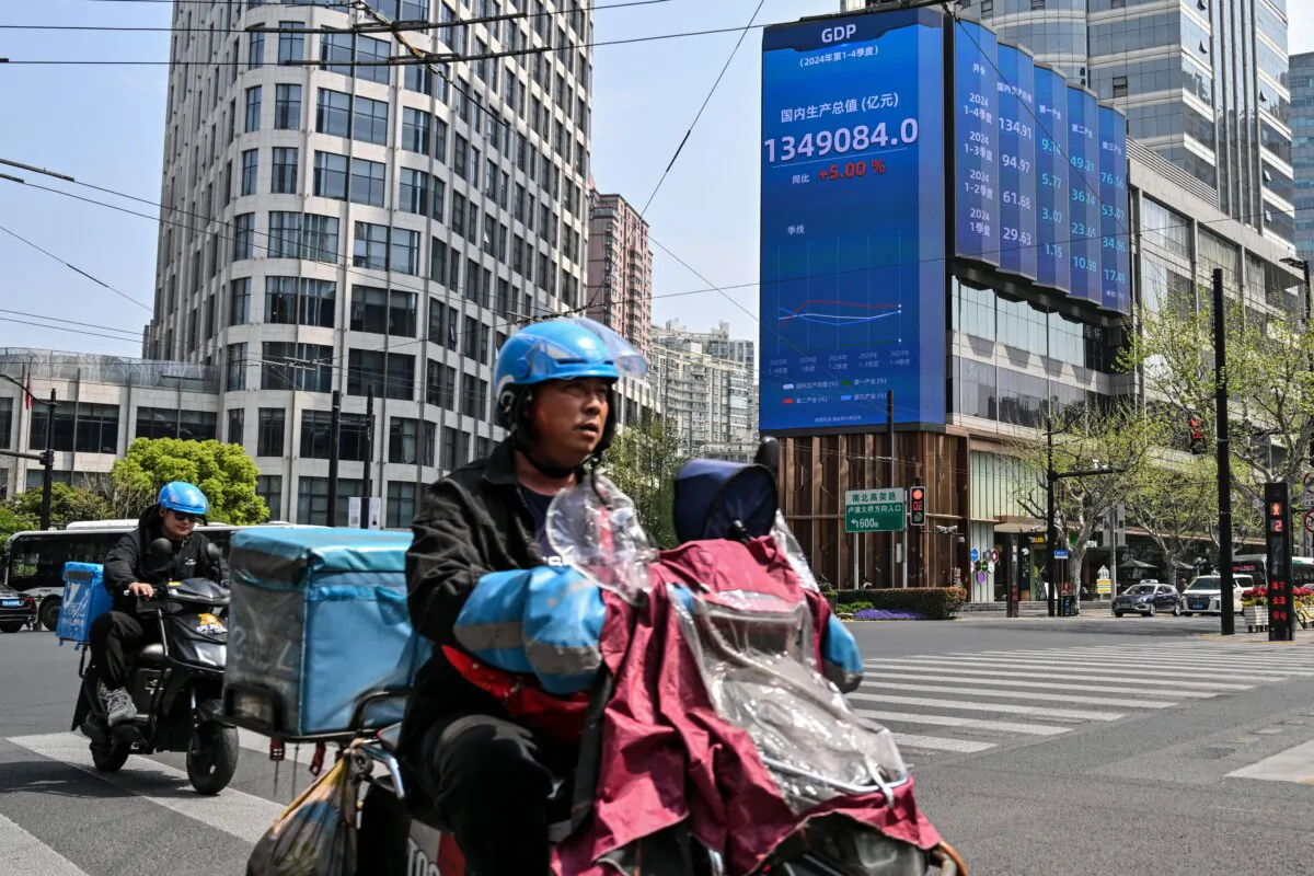 Motorists ride past a screen showing China’s gross domestic product (GDP) in the Jing'an district of Shanghai, China, on April 9, 2025. (Hector Retamal/AFP via Getty Images)