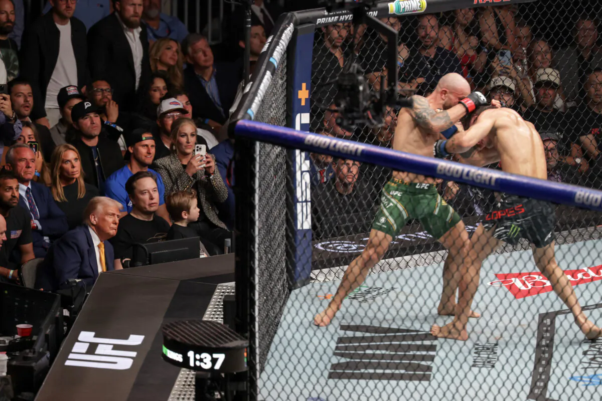 President Donald Trump, along with (L–R behind him) FBI Director Kash Patel and Health Secretary Robert F. Kennedy, Jr., Elon Musk and his son (seated to Trump's right), watch Australian fighter Alexander Volkanovski and Brazilian fighter Diego Lopes during an Ultimate Fighting Championship fight at the Kaseya Center in Miami on April 12, 2025. (Joe Raedle/Getty Images)
