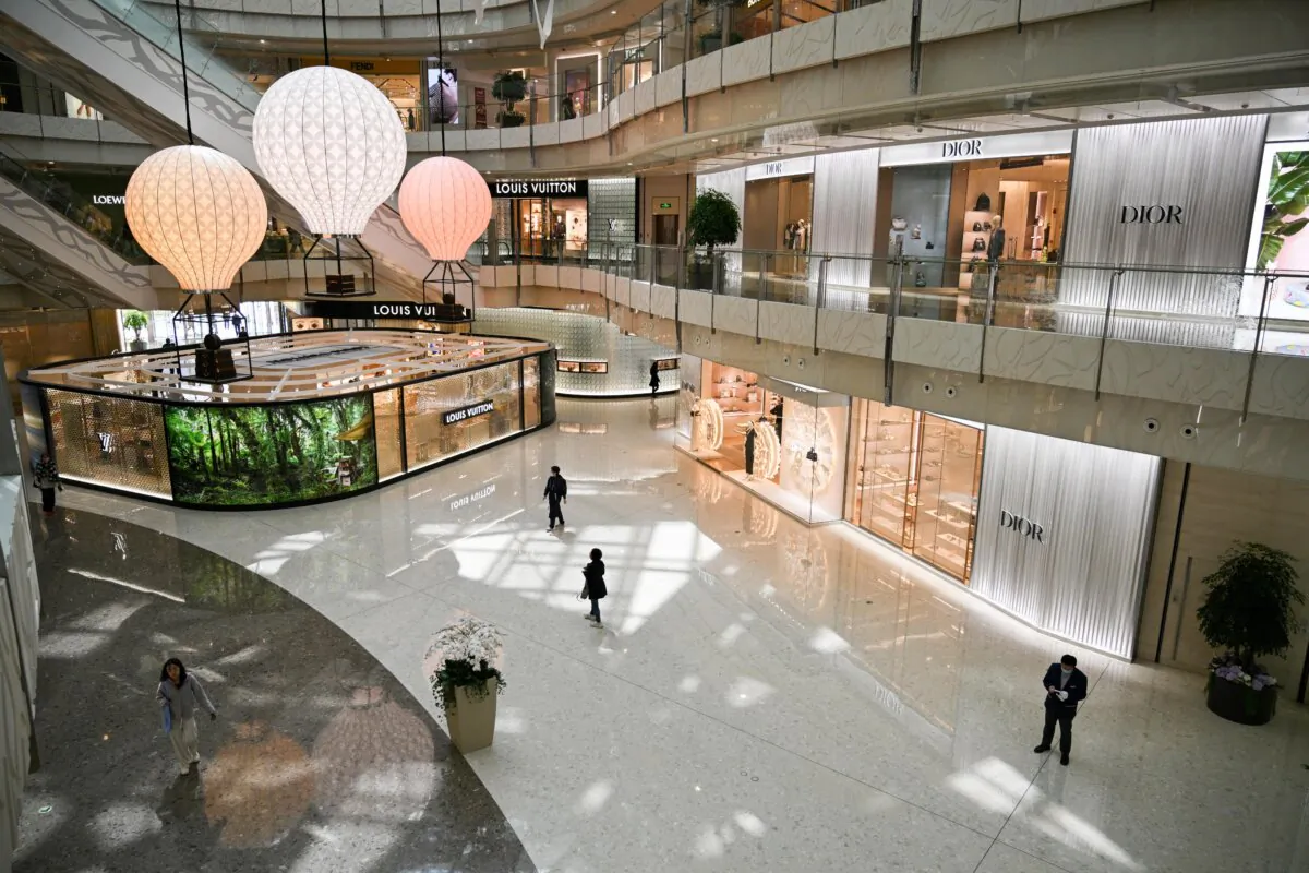 People walk past luxury brand stores at a mall in the financial district of Shanghai on April 14, 2025. (Hector Retamal/AFP via Getty Images)