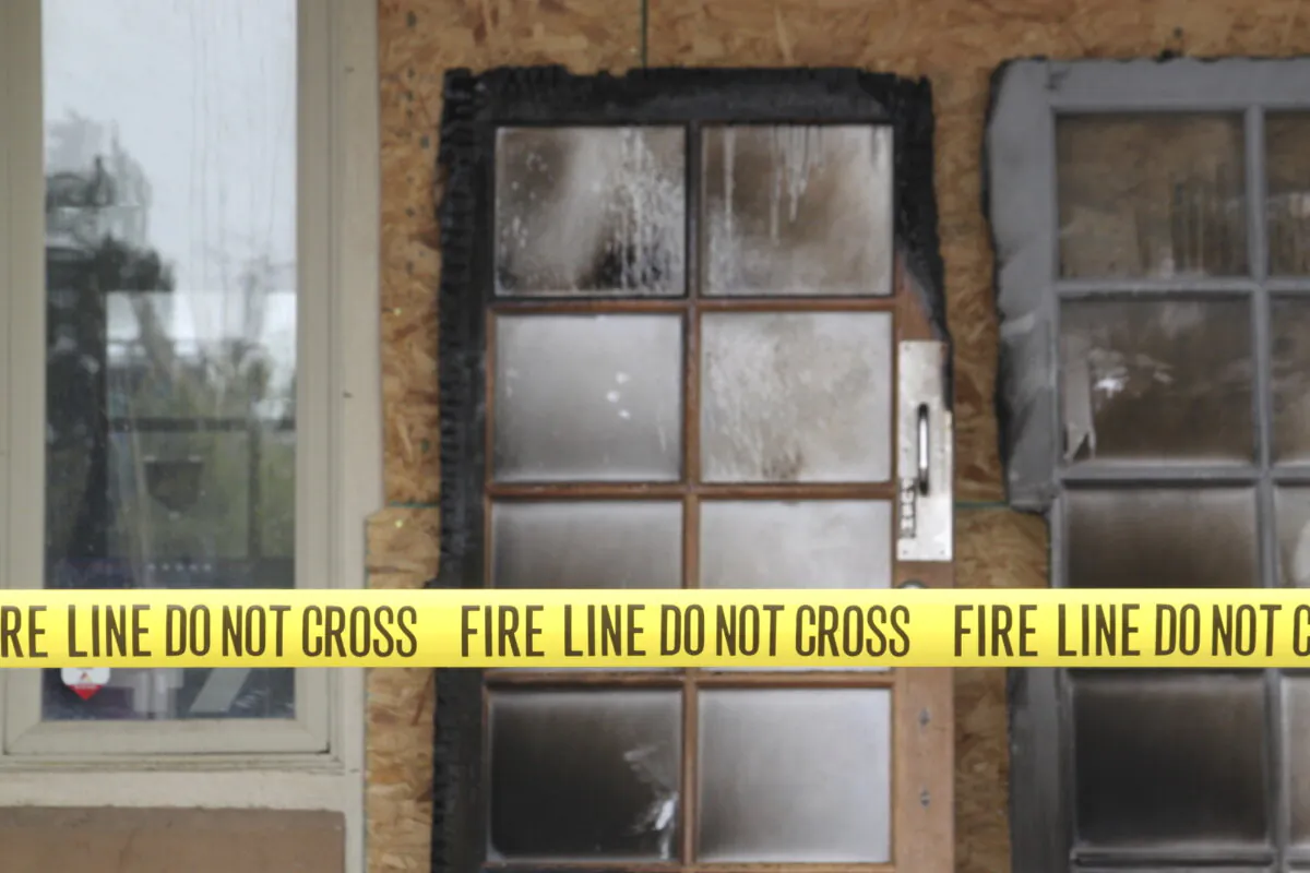 The charred doors that used to make up the entrance to the Republican Party of New Mexico headquarters are propped up behind yellow caution tape in Albuquerque, N.M., on March 31, 2025. (Susan Montoya Bryan/AP Photo)
