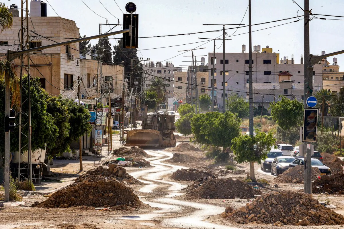 An Israeli military bulldozer is pictured along a partially-demolished road during an army operation in the Palestinian refugee camps in Tulkarem in the northwest of the occupied West Bank on April 16, 2025. (Zain Jaafar/AFP) 