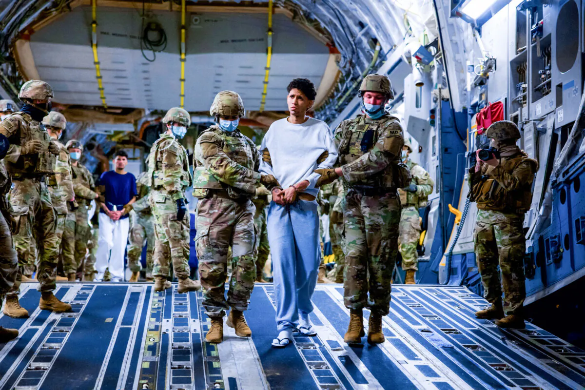 U.S. military personnel escort alleged members of the Venezuelan gang Tren de Aragua and the MS-13 gang recently deported by the U.S. government to be imprisoned in the Terrorism Confinement Center (CECOT) prison, as part of an agreement with the Salvadoran government, in San Luis Talpa, El Salvador, on March 30, 2025. (Secretaria de Prensa de la Presidencia/Handout via Reuters)