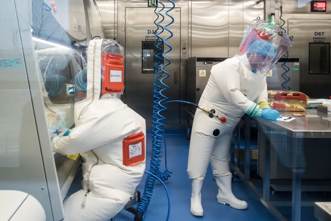 Workers next to a cage with mice inside the P4 laboratory in Wuhan, Hubei Province, China, on Feb. 23, 2017. (Johannes Eisele/AFP via Getty Images)