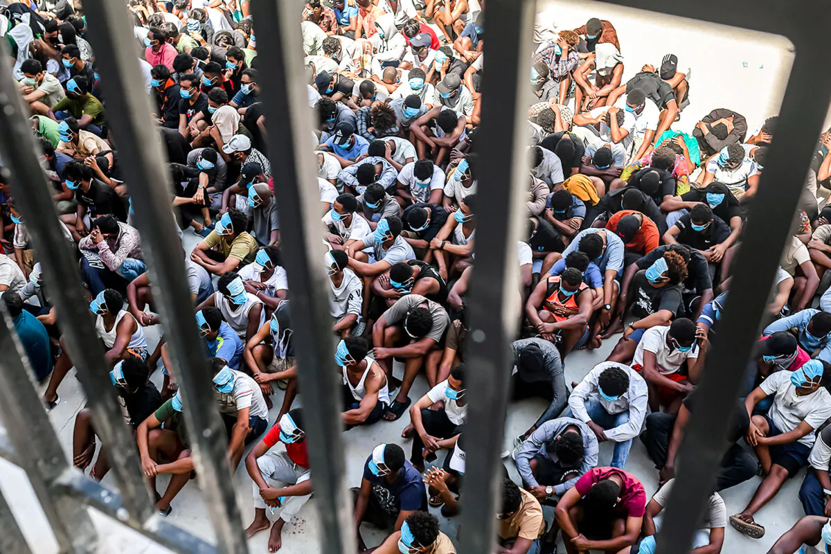 Scam center workers and victims sit on the ground during a crackdown operation by the Karen Border Guard Force on illicit activity at the KK Park complex in Myawaddy, Burma, on Feb. 26, 2025. Hundreds of foreigners are being sent home from scam compounds in Burma that are run by criminal enterprises. (STR/AFP via Getty Images)