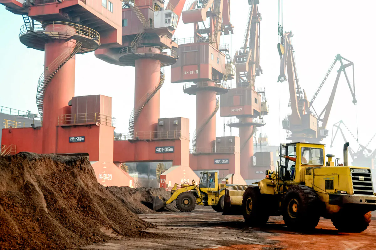 Workers transport soil containing rare earth elements for export at a port in Lianyungang, Jiangsu Province, China, on Oct. 31, 2010. (Stringer/Reuters)