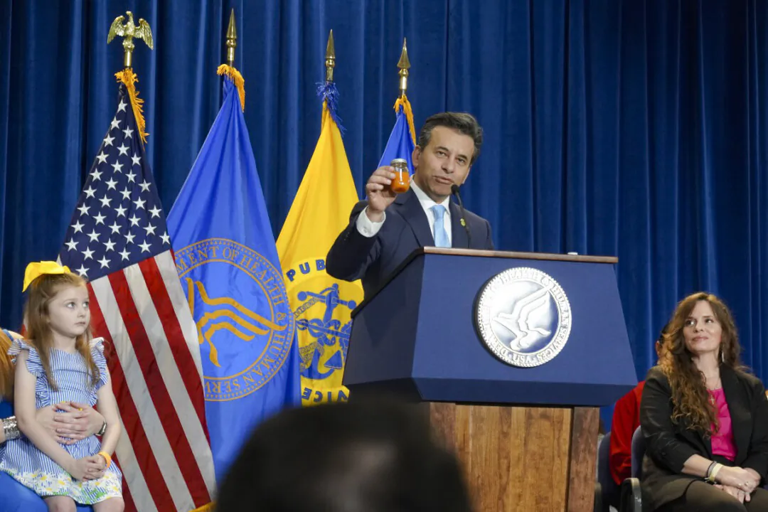 Food and Drug Administration Commissioner Dr. Martin Makary holds up a vial of carrot juice, an alternative to synthetic food dyes, at a press conference at the Hubert H. Humphrey Building in Washington on April 22, 2025. (Nathan Worcester/The Epoch Times)
