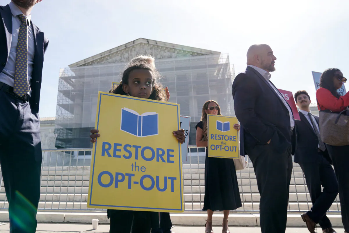 A child holds a sign as people supporting the right to opt out their children from classes containing LGBT-related content demonstrate outside the Supreme Court, as the court hears oral arguments in the Mahmoud v. Taylor case, in Washington on April 22, 2025. (Oliver Contreras/AFP via Getty Images)