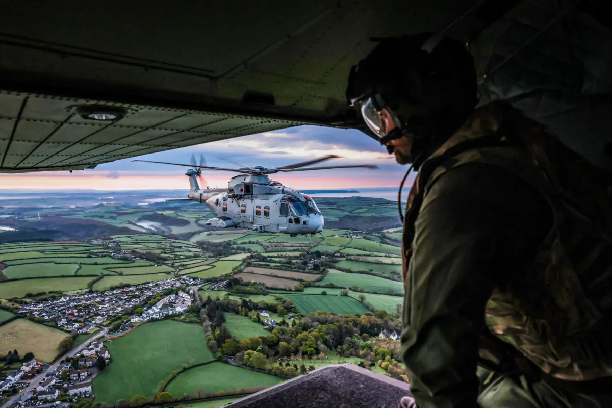 A Royal Navy Merlin helicopter hovers above the Cornish countryside in southwest England on April 24, 2025, en-route to join British aircraft carrier HMS Prince of Wales following its deployment to the Indo-Pacific region. (Richard Pohle/Pool/AFP via Getty Images)