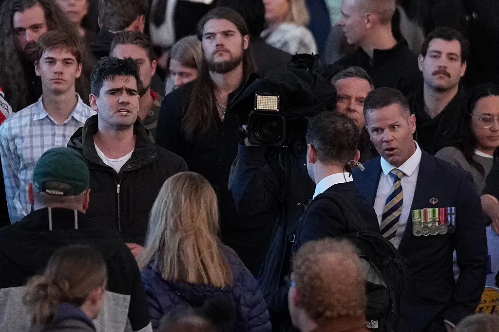Jacob Hersant (Left)  speaks to a TV journalist during the Dawn Service at the Shrine of Remembrance in Melbourne, Australia on April 25, 2025. (Asanka Ratnayake/Getty Images)
