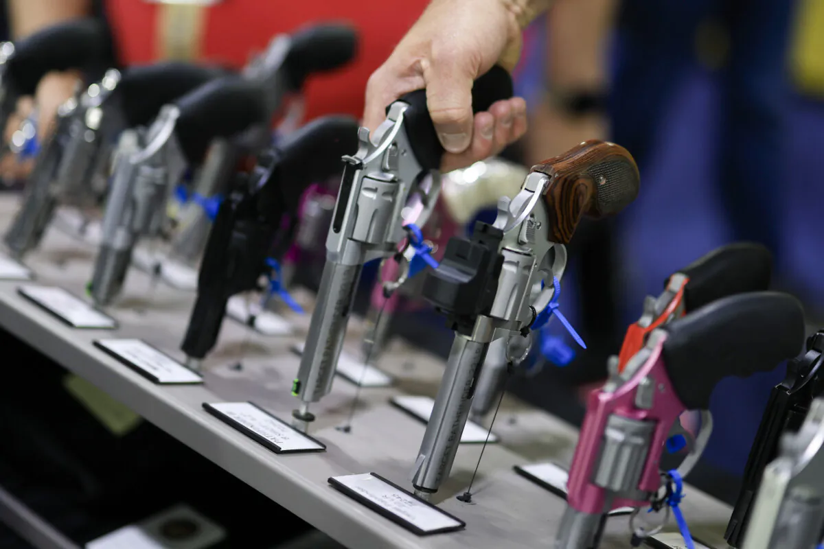 A visitor picks up a revolver at a gun show in Atlanta, Ga., on April 25, 2025. (Joe Raedle/Getty Images)