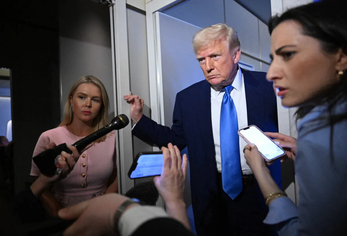 White House press secretary Karoline Leavitt listens (L) as U.S. President Donald Trump speaks to reporters while in flight on Air Force One, en route to Joint Base Andrews on April 6, 2025. (Mandel Ngan/AFP via Getty Images)