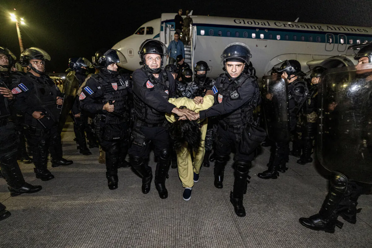 Guards escort a newly admitted inmate to the Terrorist Confinement Center (CECOT) in Tecoluca, El Salvador, on March 16, 2025. (Salvadoran Government via Getty Images)