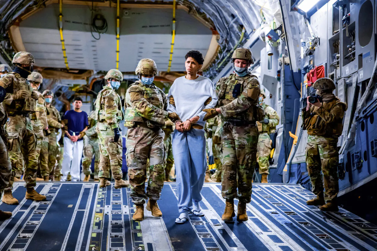 U.S. military personnel escort alleged members of the Venezuelan gang Tren de Aragua and the MS-13 gang recently deported by the U.S. government to be imprisoned in the Terrorism Confinement Center prison as part of an agreement with the Salvadoran government, in San Luis Talpa, El Salvador, on March 30, 2025. (Secretaria de Prensa de la Presidencia/Handout via Reuters)