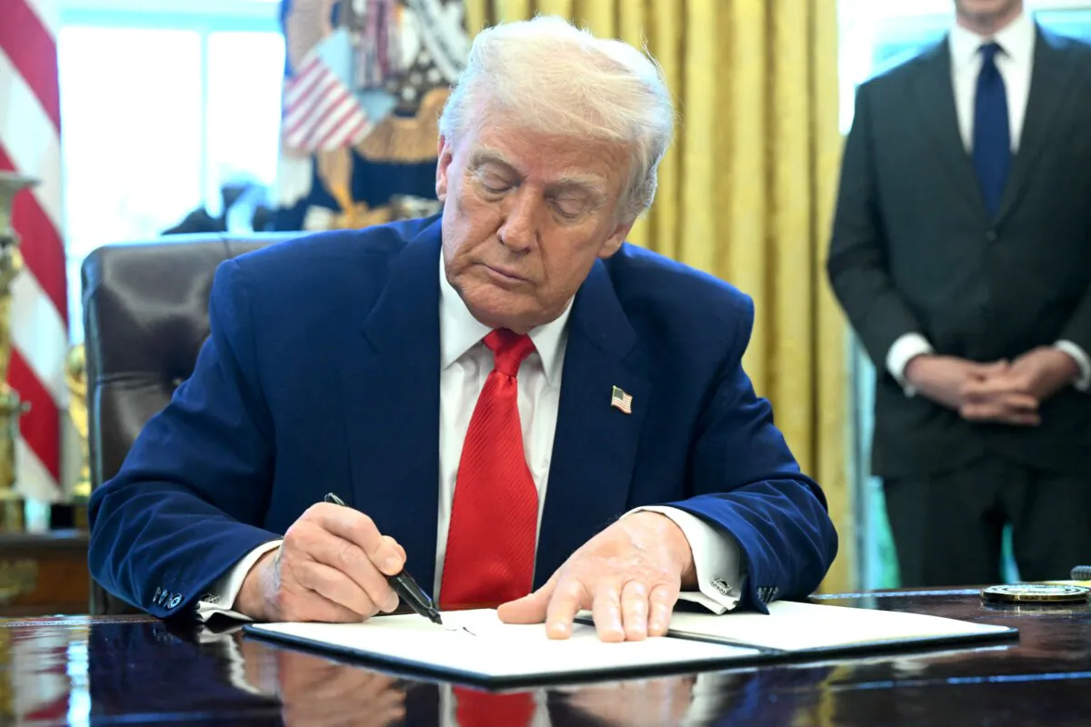 President Donald Trump signs an executive order in the Oval Office of the White House on April 9, 2025. (Saul Loeb/AFP via Getty Images)