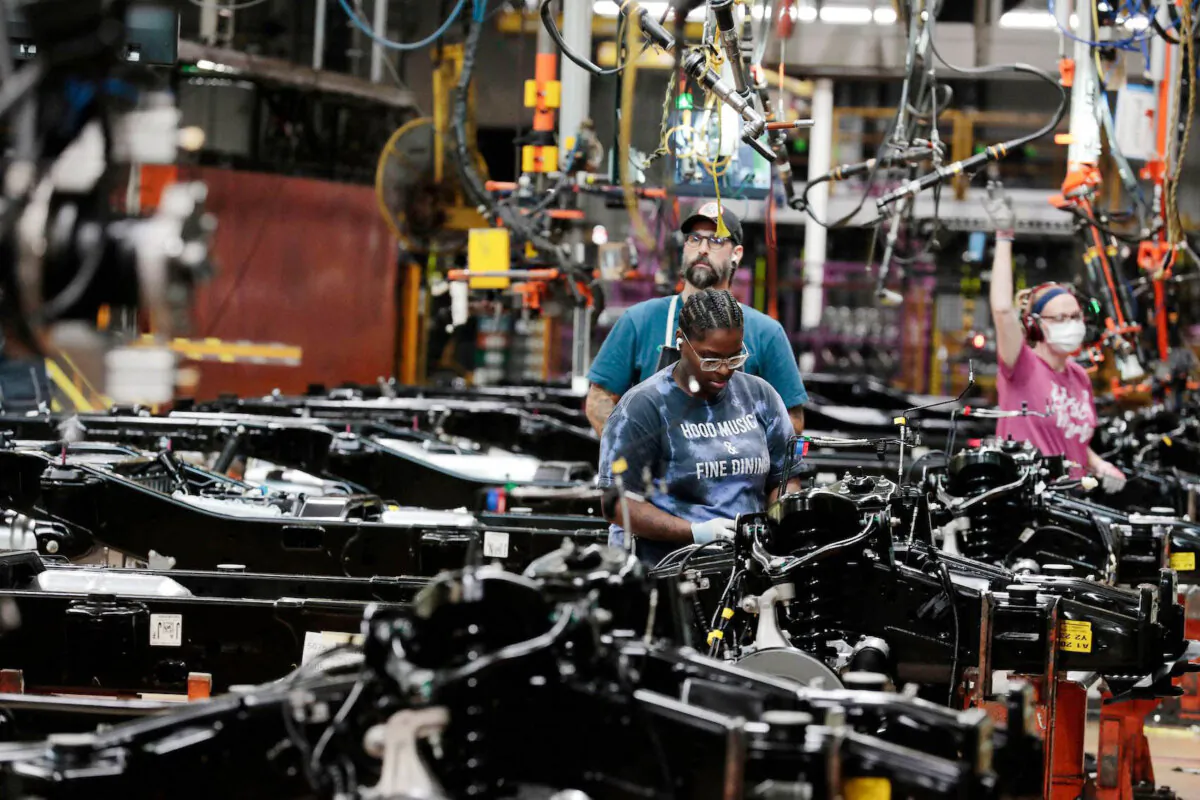 Workers put engines on the frames of Ford Motor Company fuel-powered F-150 trucks under production at its plant in Dearborn, Mich., on Sept. 20, 2022. (Jeff Kowalsky/AFP via Getty Images)