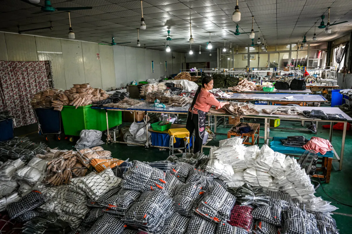 A worker packages garments for the Chinese e-commerce company Temu at a clothing factory in Guangzhou, in southern China's Guangdong Province, on April 16, 2025. (Photo by Jade Gao/AFP via Getty Images)