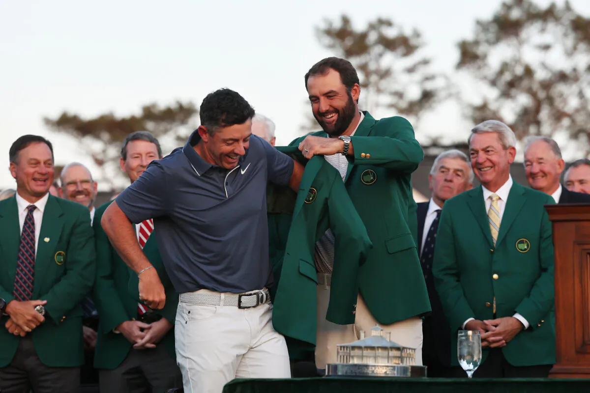 Rory McIlroy (L) of Northern Ireland is awarded the green jacket by 2024 Masters champion Scottie Scheffler after the final round of the 2025 Masters Tournament at Augusta National Golf Club in Georgia on April 13, 2025. (Michael Reaves/Getty Images)