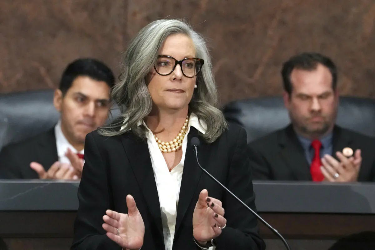 Arizona Gov. Katie Hobbs (C) applauds for those affected by the Los Angeles area wildfires as she gives the State of the State address in the House of Representatives at the Capitol, with Speaker of the House Rep. Steve Montenegro (L) and Senate President Warren Petersen (R) flanking her, in Phoenix on Jan. 13, 2025. (Ross D. Franklin / AP File)