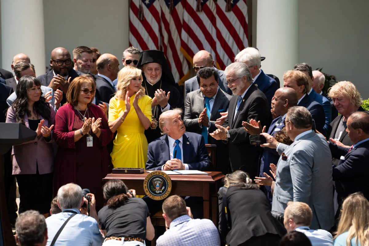 President Donald Trump signs an executive order on the "Establishment of the Religious Liberty Commission" during the National Day of Prayer event at the Rose Garden of the White House on May 1, 2025. (Madalina Vasiliu/The Epoch Times)