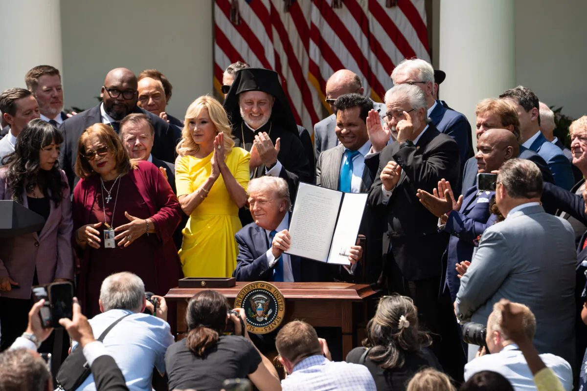 President Donald Trump signs an executive order to establish the Religious Liberty Commission during the National Day of Prayer event at the White House Rose Garden on May 1, 2025. (Madalina Vasiliu/The Epoch Times)