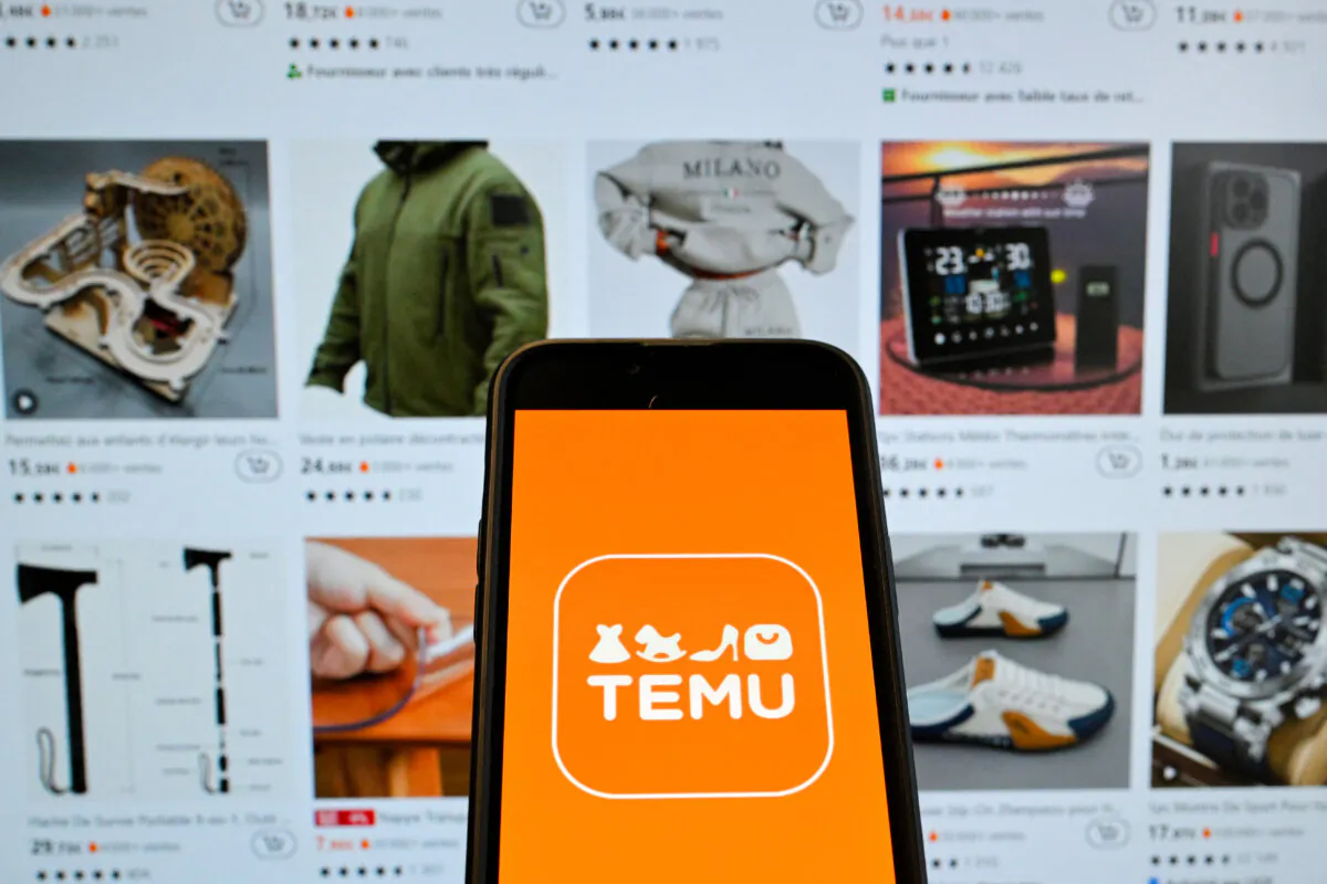 The logo of Chinese e-commerce company Temu displayed on a mobile phone held in front of a screen bearing a website page of the e-commerce company, in Brussels, on Nov. 4, 2024. (Photo by NICOLAS TUCAT/AFP via Getty Images)