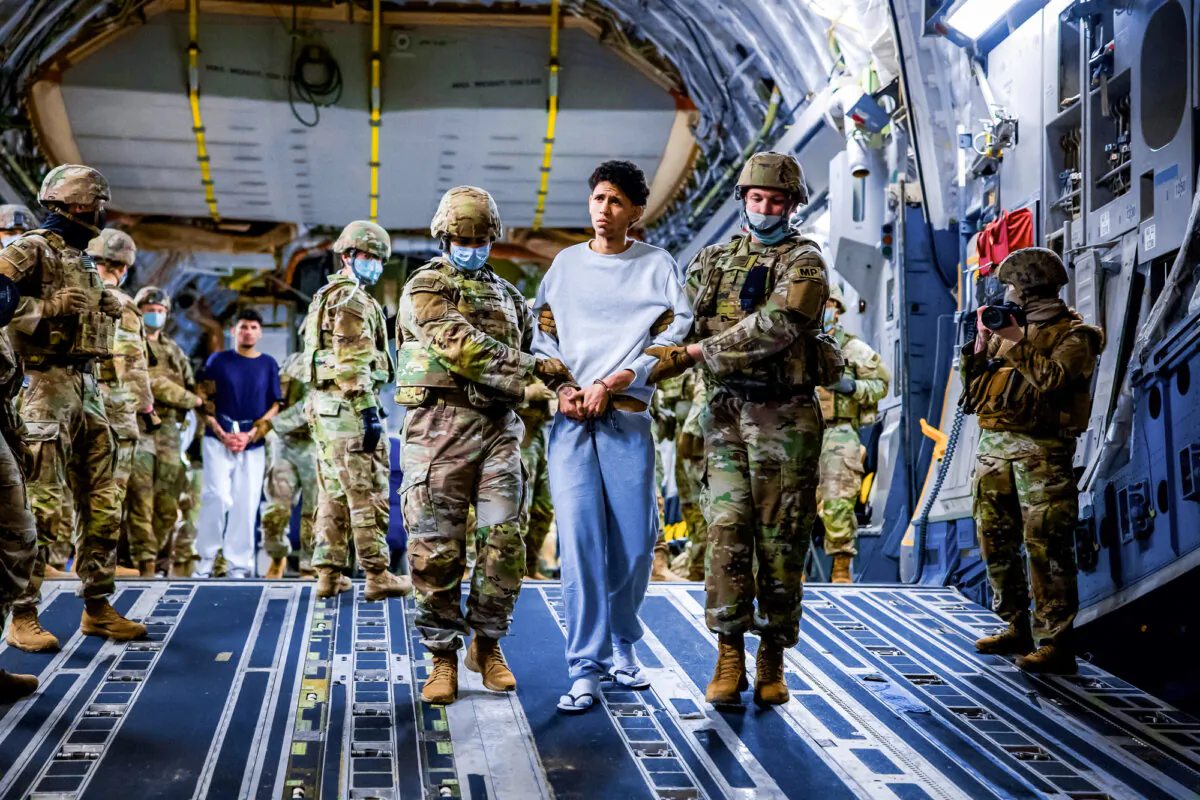 U.S. military personnel escort alleged members of the Venezuelan gang Tren de Aragua and the MS-13 gang recently deported by the U.S. government to be imprisoned in the Terrorism Confinement Center (CECOT) prison, as part of an agreement with the Salvadoran government, in San Luis Talpa, El Salvador, on March 30, 2025. (Secretaria de Prensa de la Presidencia/Handout via Reuters)