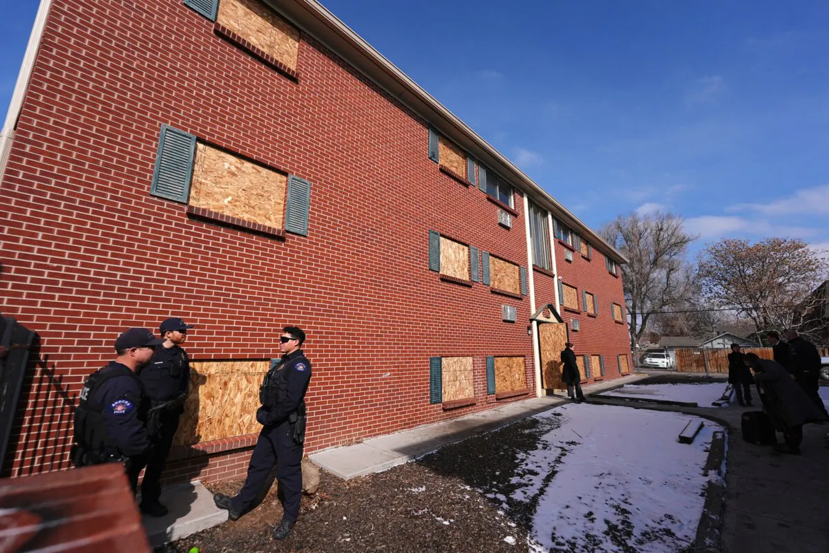 Officers gather outside one of the condemned buildings of an apartment complex called The Edge at Lowry after a news conference to outline that the five housing structures have been closed by the city, in Aurora, Colo., on Feb. 19, 2025. (David Zalubowski/AP Photo)