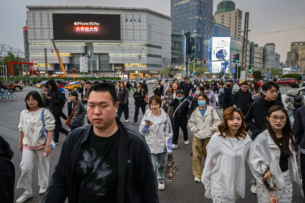 People cross at a traffic light in Beijing on April 8, 2025. (Kevin Frayer /Getty Images)
