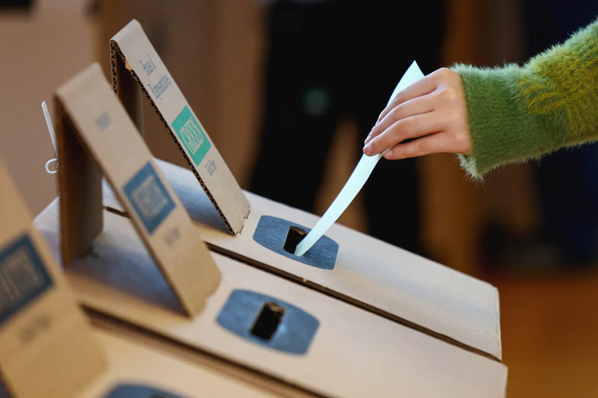 People drop their vote into the voting box at Kew Primary School in Melbourne, Australia on May 3, 2025. (Morgan Hancock/Getty Images)