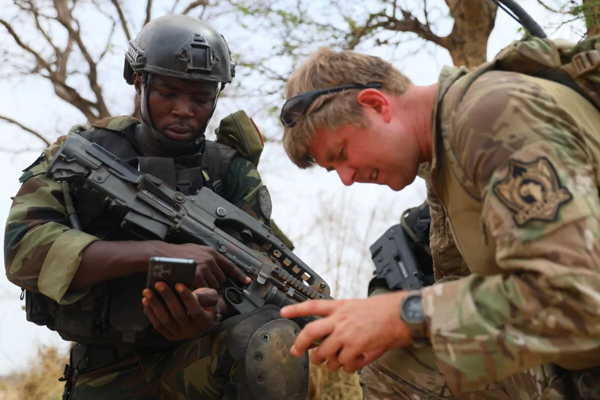 A Cameroonian soldier (L) interacts with a U.S. soldier at a counter-terrorism training session during the Flintlock 2023 military training hosted by the International Counter-Terrorism Academy with U.S. Special Forces in Daboya, in the Savannah region of Ghana, on March 11, 2023. (Nipah Dennis/AFP via Getty Images)