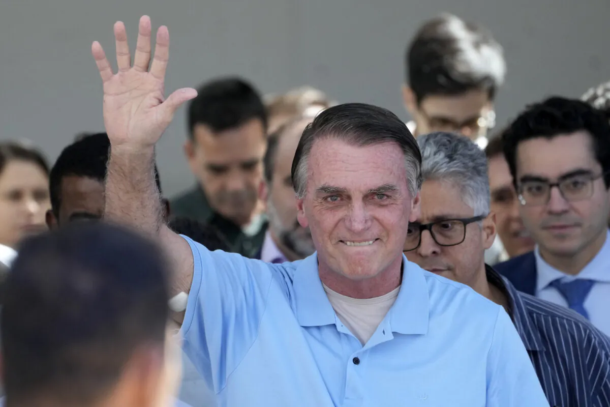 Former Brazilian President Jair Bolsonaro waves to supporters as he leaves the hospital after a weeks-long surgical stay, in Brasilia, Brazil, on May 4, 2025. (Eraldo Peres/AP Photo)