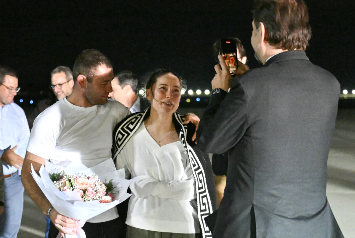 Senior Director for Counterterrorism Sebastian Gorka takes a picture of U.S.-Russian ballet dancer Ksenia Karelina and her boyfriend South African boxer Chris van Heerden at Joint Base Andrews in Maryland, following Karelina's release from Russia, on April 10, 2025. (Roberto Schmidt/AFP via Getty Images)
