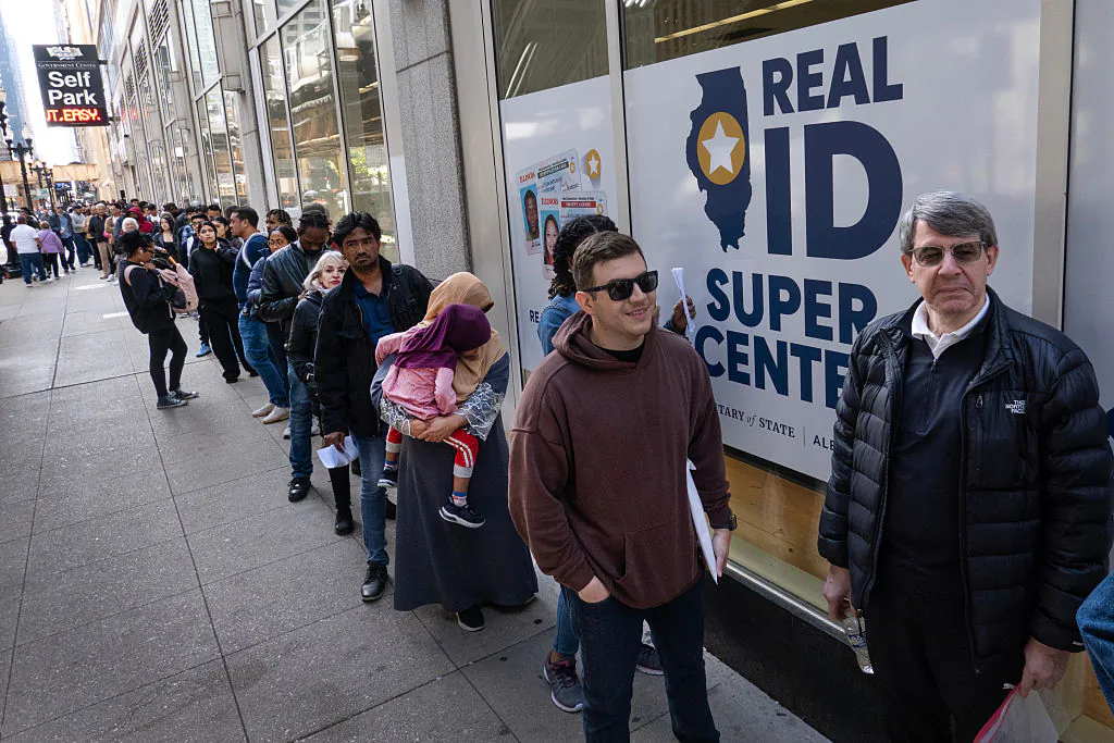 Illinois residents wait in a line that stretches nearly two blocks to enter the Real ID Super Center operated by the Secretary of State's office to apply for a Real ID on May 6, 2025 in Chicago, Illinois. Starting tomorrow, a drivers license or state ID will no longer be considered acceptable forms of identification to board a domestic flight. Travelers will need to present a Real ID, passport or other acceptable form of identification at airport security checkpoints to avoid additional screening or risk being denied access to their flight. (Scott Olson/Getty Images)