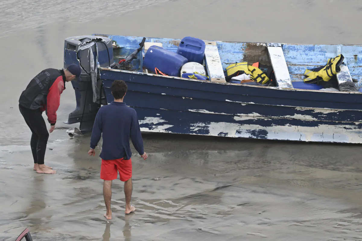 Del Mar lifeguards looks over a capsized boat at Torrey Pines State beach in San Diego on May 5, 2025. (Denis Poroy/AP Photo)