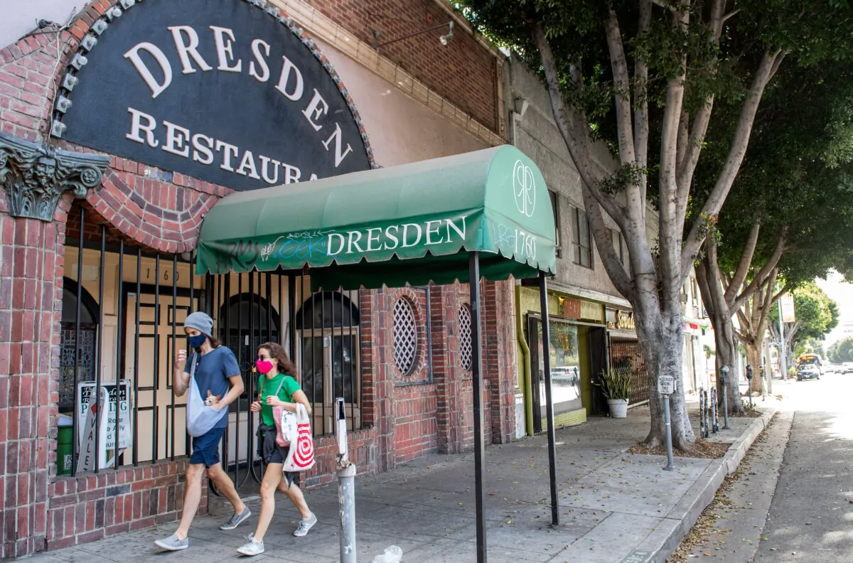 People walk past a closed restaurant amid pandemic restrictions and lockdowns in Los Angeles on Dec. 8, 2020. (Valerie Macon/AFP via Getty Images)